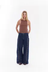 Top musculosa blanco de canalé con cuello redondo, corte ajustado y detalle de botones a presión en el lateral.