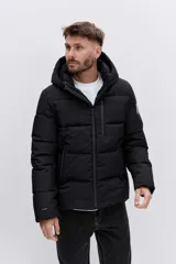 Cazadora acolchada negra con capucha, cierre frontal con cremallera y diseño de paneles horizontales. Presenta un parche decorativo en la manga y un ajuste cómodo.