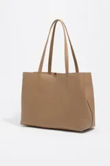 Bolso shopper de piel color borgoña, con textura granulada, asas de hombro y cierre de cordón. Presenta el logo metálico de Bimba y Lola en el frente.