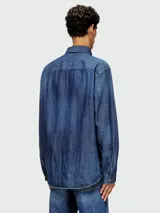 Camisa de jean azul de manga larga con logo rojo bordado en el pecho.