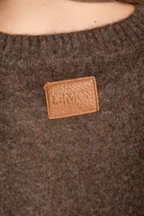 Sweater de tejido de punto con diseño color block. Cuerpo principal en beige jaspeado, mangas y puños en azul marino, y detalles en marrón en el cuello y puños.