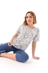 Conjunto de pijama de algodón color champagne, compuesto por una remera de manga corta con cuello henley y bolsillo en el pecho, y un pantalón capri a rayas horizontales celestes y blancas.