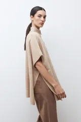 Sweater oversized color verde petróleo, con cuello alto y cierre frontal corto.