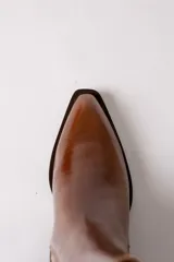 Bota de cuero negro estilo texano, con caña media, elástico lateral con costuras verticales y taco cuadrado.