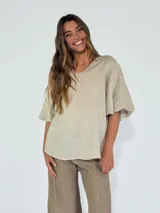 Blusa beige de lino con escote en V y mangas cortas amplias.