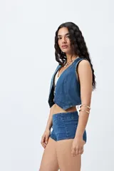 Microshort de tiro bajo color negro, con cierre metálico en la espalda, de calce ajustado y largo mini.