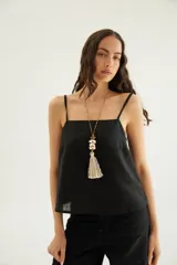 Top negro de lino con escote recto, tirantes finos regulables y diseño holgado.