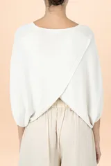 Poncho de punto en color marfil, con diseño de caída relajada, cuello redondo y mangas holgadas.