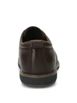 Zapato casual Hush Puppies modelo Bolo, confeccionado en cuero color marrón oscuro. Presenta cierre con cordones, suela de EVA flexible y diseño estilizado con costuras visibles en el borde de la suela.