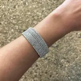 Pulsera plateada de strass con múltiples hileras.