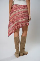 Minifalda asimétrica de crochet con diseño de ondas en tonos rojo, rosa y beige.