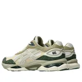 Championes Asics modelo Gel-Nyc 2.0, con diseño robusto y combinación de tonos blanco, beige, verde oscuro y detalles en gris. Incorporan tecnología GEL en la suela y una mezcla de texturas de malla y gamuza.