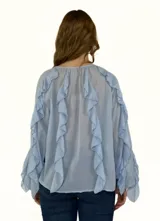 Camisa blanca con escote en V y volados en el frente y mangas 3/4 abullonadas.