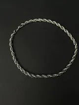 Collar de cadena con eslabones trenzados de diseño robusto y versátil. Fabricado en acero inoxidable con recubrimiento en tono dorado.