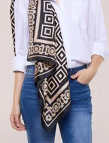 Pashmina de satén con estampado geométrico en tonos negros, beige y dorados, de forma rectangular y gran tamaño.