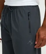 Pantalón deportivo de corte recto confeccionado en tejido técnico de poliamida y elastano. Presenta cintura elástica con cordón ajustable, bolsillos laterales con cierre y sistema de regulación en el ruedo para un ajuste personalizado.