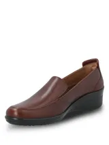 Zapato slip on color marrón de cuero liso lustrado, con taco enterizo negro y costuras visibles en el empeine.