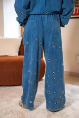 Pantalón azul de corte recto y fluido, con ojales metálicos integrales.