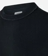 Remera negra de algodón con corte oversized, cuello redondo y manga corta. Presenta un tejido acanalado y un dobladillo sin rematar.