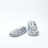 Pantuflas de tela suave con diseño de estampado animal print en tonos grises y blancos, forradas en su interior con material afelpado.