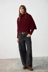 Capita de tejido de punto acanalado en color bordó, con cuello alto y diseño sin mangas con aberturas laterales.