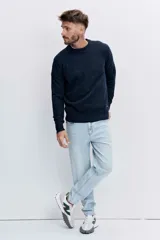 Pantalón de jean corte regular, color celeste claro, con diseño de cinco bolsillos y cierre frontal con botón y cremallera.