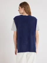 Chaleco de punto sin mangas color azul marino, con escote en V, hombros extendidos y aberturas laterales, confeccionado en suave cachemira con textura afelpada.