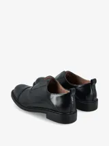 Mocasín tipo slip-on de cuero color marrón, con diseño minimalista, puntera reforzada y suela plana de goma negra.