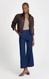 Jean de tiro alto confeccionado en denim azul oscuro, con corte pantacourt de pierna recta y ancha. Presenta cintura estructurada sin pretina, cierre frontal con cremallera y botón, bolsillos traseros y bajo con costuras visibles en contraste.