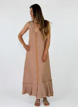 Vestido largo sin mangas, con escote en V, corte holgado y detalles de volados con flecos en el ruedo.