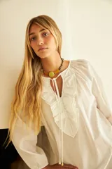 Vestido largo blanco de algodón con mangas largas abullonadas y cuello redondo con detalle de bordado. Presenta aberturas laterales en el ruedo.