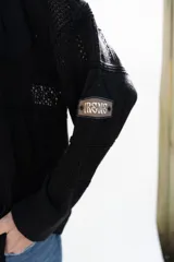 Cardigan de punto color marrón, abierto con botones imitación hueso, manga larga con parche bordado y diseño texturado.