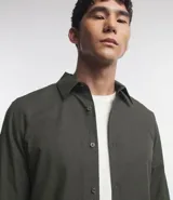 Camisa de manga larga confeccionada en tricolina de algodón, con cuello inglés, cierre frontal de botones y puños abotonados. Diseño liso y versátil.