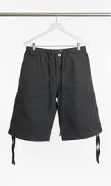 Bermuda cargo verde oscuro con cintura ajustable con cordón. Presenta bolsillos laterales tipo cargo y ajuste con cordón en el ruedo.