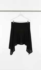 Falda negra con cintura alta y bajo irregular. El largo se puede ajustar con la faja.