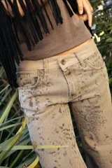 Jean de tiro medio con silueta recta levemente acampanada, confeccionado en gabardina con estampado tipo cowhide print. Cuenta con cierre frontal, botón y bolsillos funcionales.