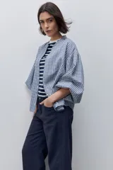 Pantalón jean de tiro alto con calce straight y pierna recta, confeccionado en denim de aspecto limpio. Cuenta con cinco bolsillos, cierre frontal con botón y presillas para cinturón.