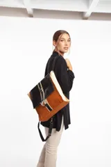 Mochila de cuero vacuno color negro, con tapa de cuero con textura croco color bordó y detalles en blanco. Tiene mosquetón de seguridad exterior, cierre interior, dos bolsillos interiores (uno con cierre y otro para celular), sujetador de llaves, forro completo y tiras ajustables. Se puede usar como mochila o como cartera.