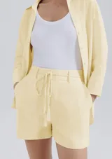 Shorts de lino color beige, de talle alto con presillas para cinto y bolsillos laterales.