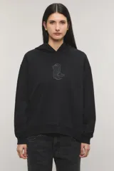 Buzo hoodie oversize negro, confeccionado en rústico de algodón y poliéster, con capucha, bolsillo tipo canguro y detalle de estampa de botas vaqueras con tachas en el centro del pecho.