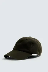 Gorra de algodón color verde oscuro, con efecto lavado y visera curva. Presenta un bordado discreto en el frente.