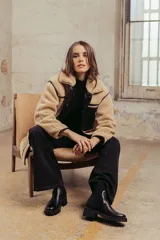 Bota de caña media color negro, con diseño tipo chelsea, suela track con detalle de tachas metálicas en el borde y elástico lateral.