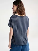 Blusa de manga corta con cuello redondo y estampado de cuadrícula blanca sobre fondo color tostado.