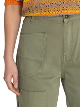 Pantalón estilo cargo de tiro alto, confeccionado en algodón orgánico. Presenta diseño con detalles de patchwork en dos tonalidades de verde, cierre tradicional, bolsillos frontales y refuerzos en las rodillas.