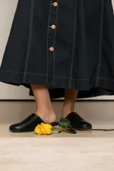 Falda larga de jean azul oscuro con pespuntes en color ocre y botones frontales. De corte acampanado y buena caída.