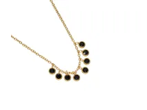 Collar dorado de acero con ocho dijes redondos con circonias negras y borde dorado.