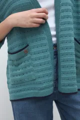 Kimono tejido de punto color verde petróleo, con mangas tres cuartos y bolsillos frontales con ribetes en contraste.