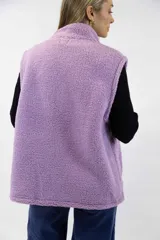 Chaleco de corderito color rosado, con cuello alto, cierre frontal y un bolsillo con cierre en el pecho.