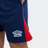 Short deportivo Umbro del Club Nacional de Football, color azul marino con detalles en rojo y blanco, escudo del club en la pierna derecha y logo de la marca en la izquierda.