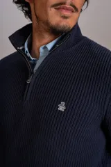 Sweater de punto acanalado color azul marino, con cuello alto y cierre frontal parcial. Presenta el logo de la marca bordado en el pecho y puños con terminación elástica.